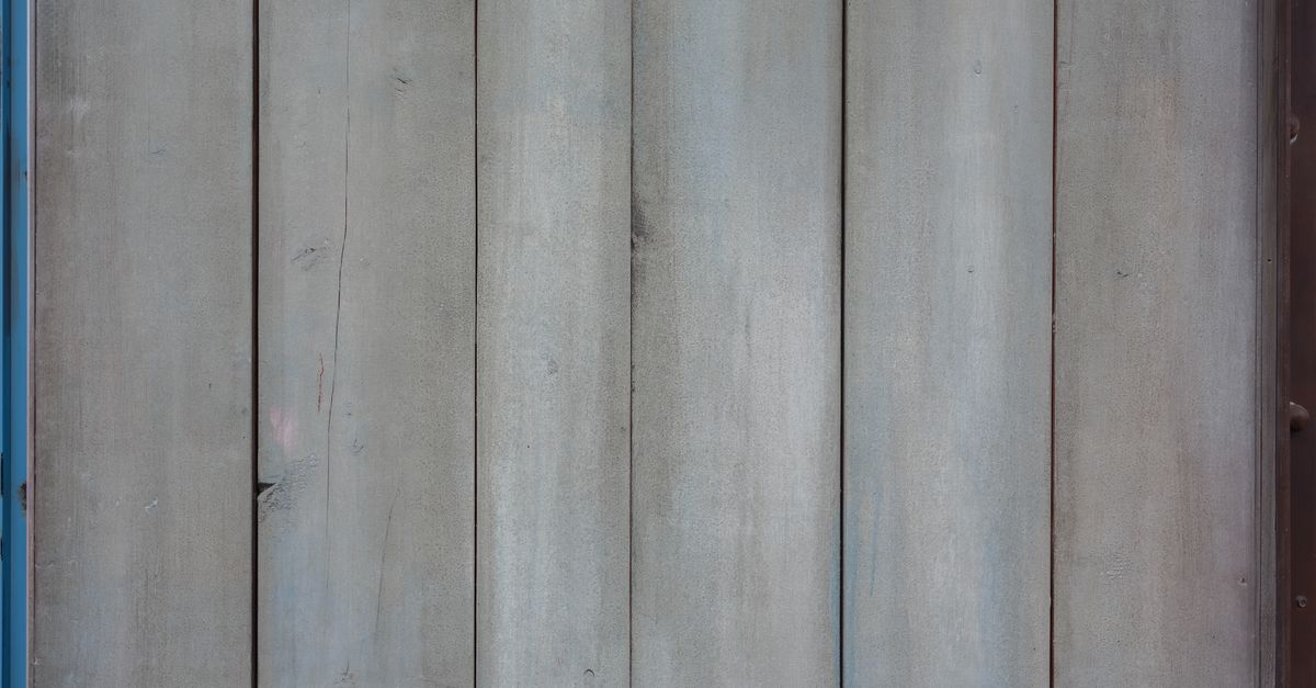 Paneles de escenografía con textura desgastada y herramientas de taller sobre el piso
